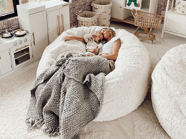 Mom and baby napping peacefully in a Lovesac SuperSac.