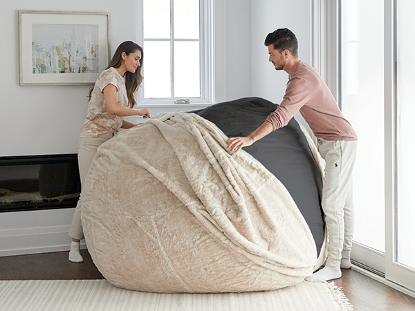 Couple changing the cover of their Lovesac.